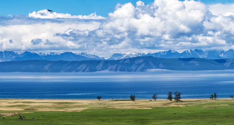 Hermosa vista panorámica del lago y las montañas bajo un cielo nublado.