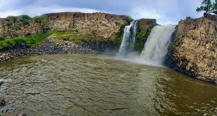 Una cascada que fluye hacia una piscina circular.