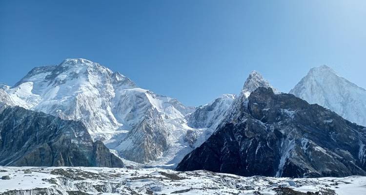 Mountain peaks covered in snow under a clear blue sky.