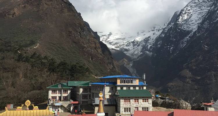 Mountain lodge in a valley with snow-capped mountains.