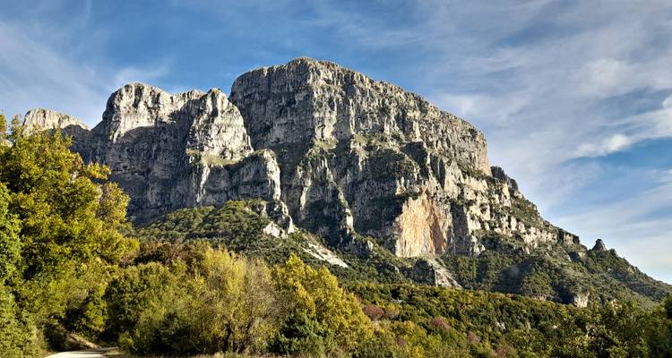 Impresionante macizo de piedra caliza se eleva dramáticamente sobre el colorido bosque otoñal.