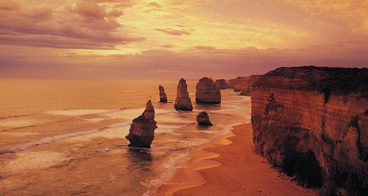 The Twelve Apostles rock formations during a dramatic sunset.