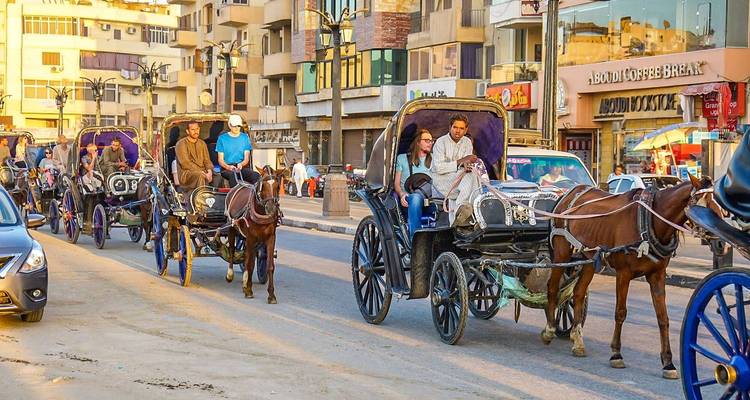 Horse-drawn carriages with tourists in Luxor.