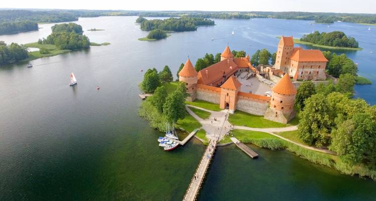 Vista aérea del Castillo de la Isla de Trakai rodeado de lagos y veleros.