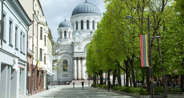 Vista de la calle de una iglesia en Kaunas, Lituania con gente caminando.