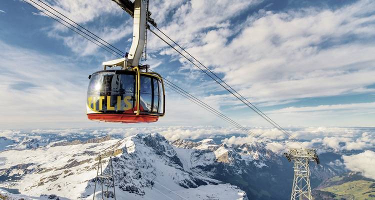 Téléphérique avec vue panoramique sur les montagnes enneigées.