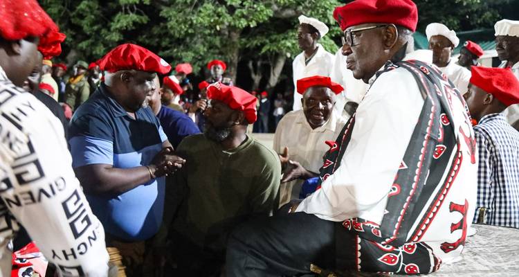 Rassemblement traditionnel avec des personnes en tenue culturelle et chapeaux rouges.