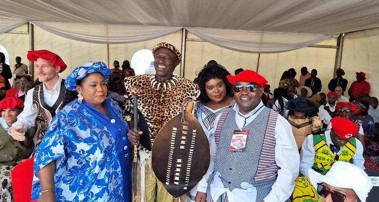 Photo de groupe avec des personnes vêtues de vêtements traditionnels colorés.