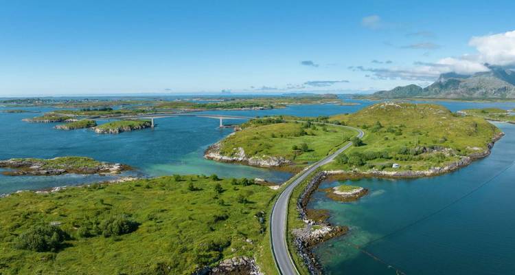 Vue aérienne d'un pont sinueux et d'une route traversant de petites îles vertes dans une eau bleu clair.