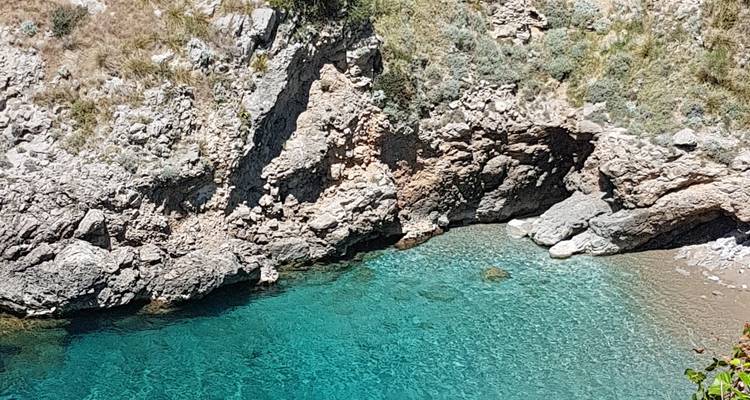 Vista de cerca de una costa rocosa y agua clara.