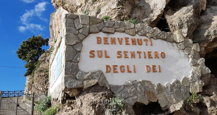 Letrero de bienvenida incrustado en una pared de roca en un sendero.
