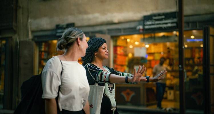 Two people walking in a marketplace.