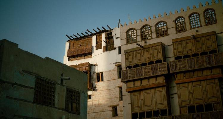 Traditional buildings with wooden features under blue sky.
