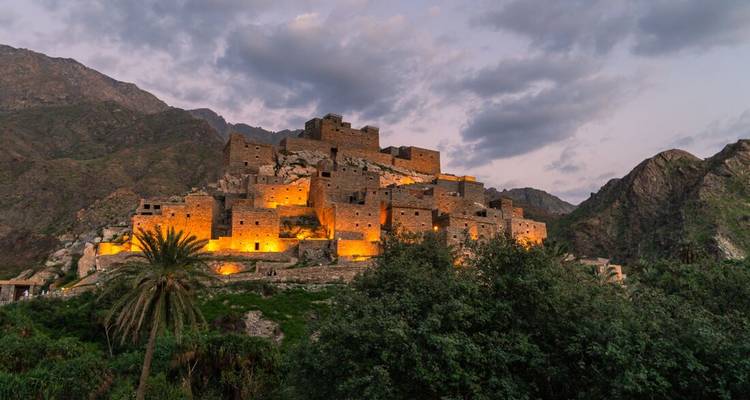 A scenic view of a lit-up village on a mountain.