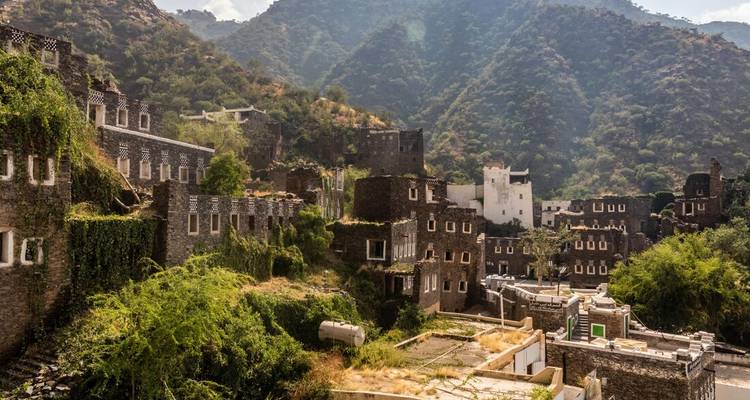 A view of traditional stone architecture in a lush mountain setting.