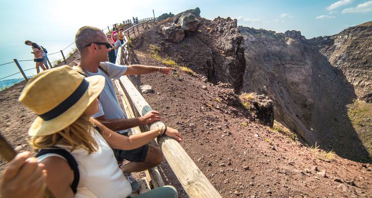 Turistas admirando un cráter volcánico desde un mirador.
