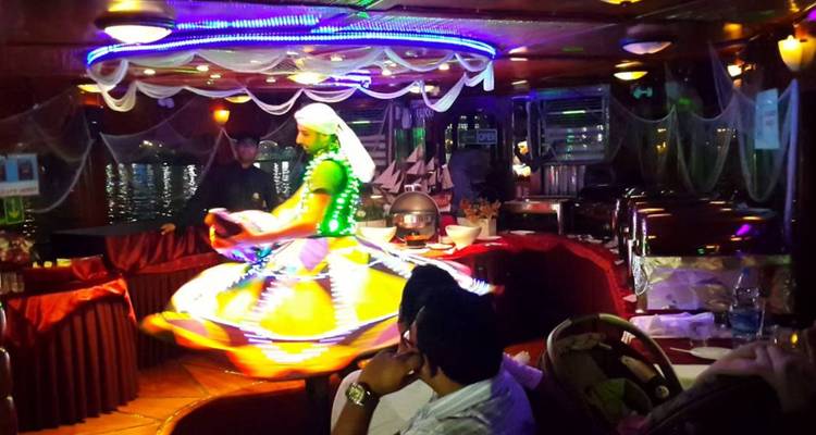 Intérprete en traje tradicional girando en el interior de un barco.