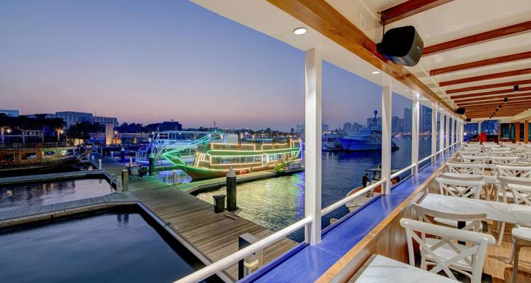 Vista desde un barco mirando hacia el puerto deportivo y la ciudad al atardecer.