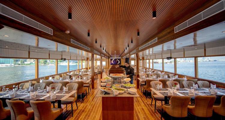 Lujosa área de comedor en un barco con vista al agua.