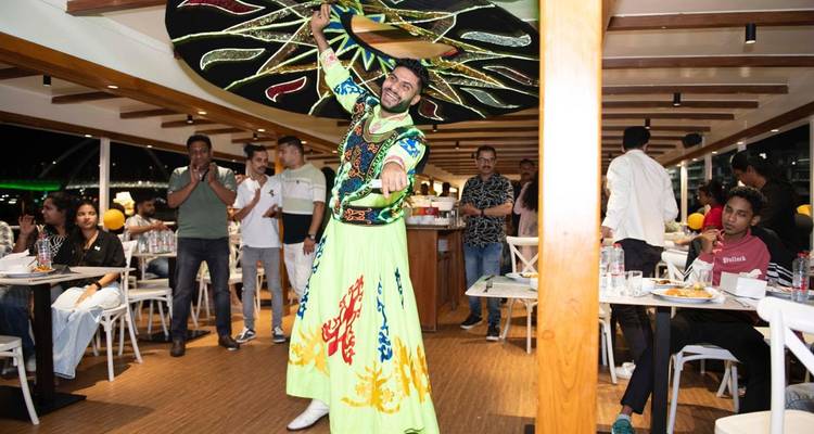 Artista con un sombrero giratorio entreteniendo a los huéspedes en un barco.
