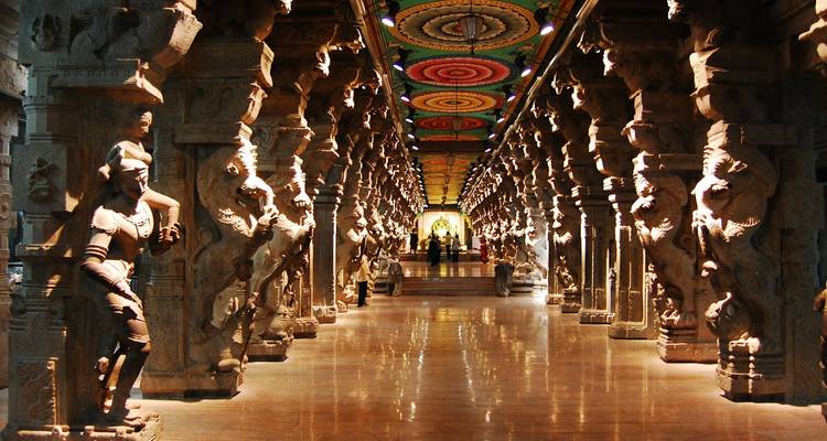 Temple ancien avec des piliers sculptés et un plafond coloré.