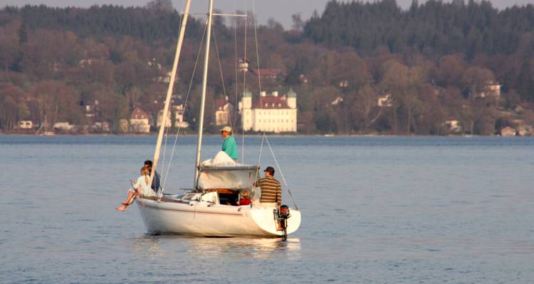 Des gens sur un voilier sur un lac calme.