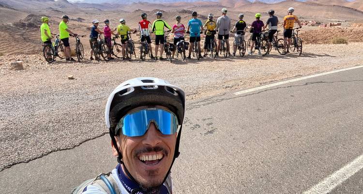 Selfie mit einer langen Reihe von Radfahrern und trockenen Hügeln, die sich in die Ferne erstrecken