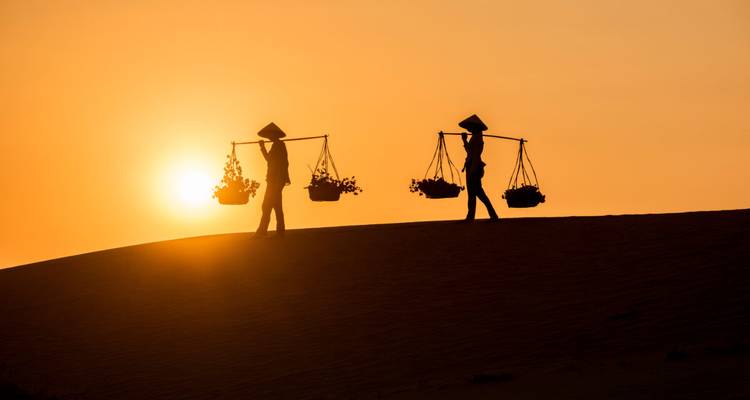 Silueta de personas con canastas al atardecer