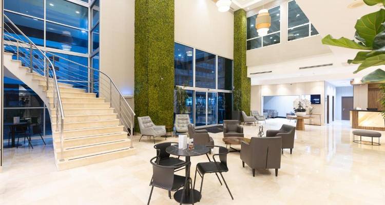 Vestíbulo de hotel moderno con techo alto y área de descanso