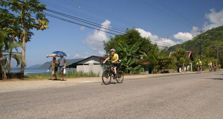 Cyclistes roulant le long d'une route côtière avec une vue panoramique.