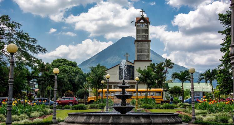 Place centrale avec fontaine et vue sur un volcan.