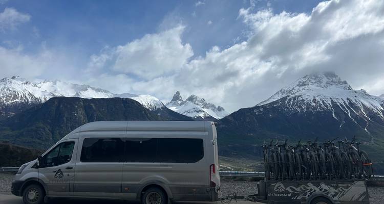 Fourgonnette et vélos près de montagnes enneigées.