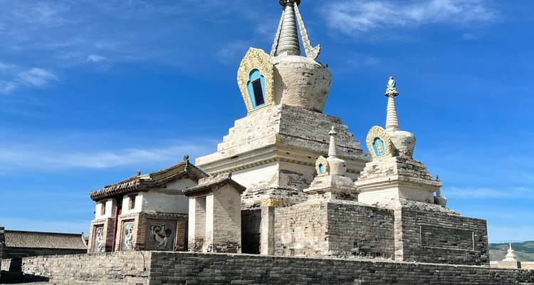 Una estupa blanca histórica con detalles intrincados contra un cielo despejado.