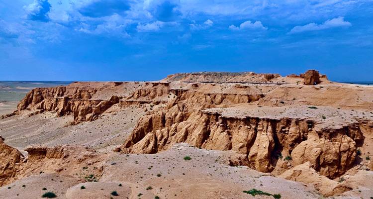 Acantilados escarpados bajo un cielo azul en un entorno desértico.
