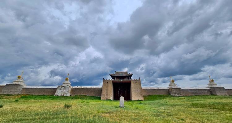 Antiguas murallas de fortaleza con un cielo nublado dramático.