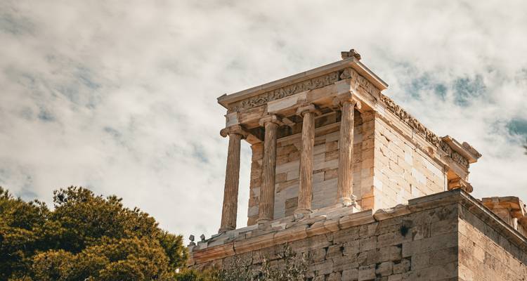 Nahaufnahme des klassischen Tempels der Athena Nike auf der Akropolis vor einem teilweise bewölkten Himmel