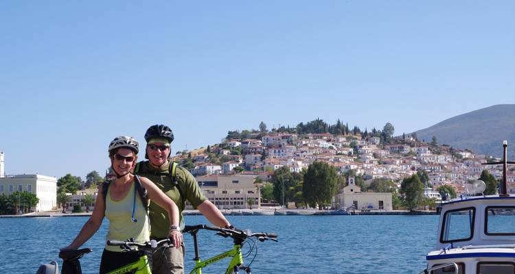 Couple à vélo avec une ville pittoresque en arrière-plan.