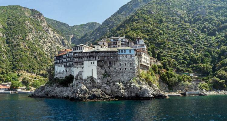 Monastère perché sur un rocher avec de luxuriantes montagnes qui l'entourent.
