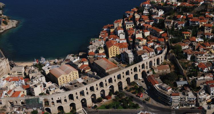 Vue aérienne d'un aqueduc historique et d'une ville côtière.