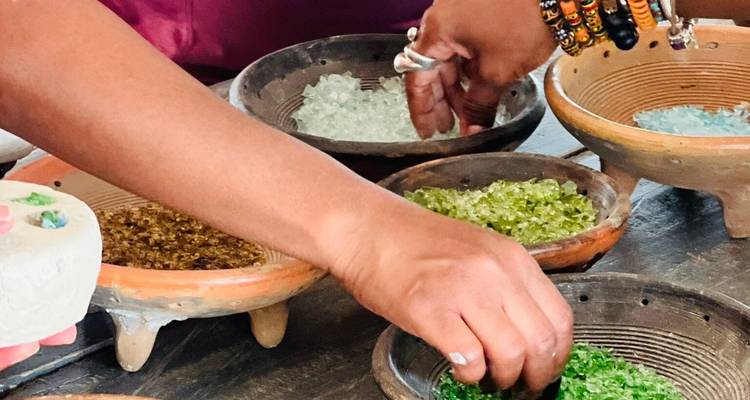 Primer plano de manos trabajando con cuentas coloridas en recipientes.