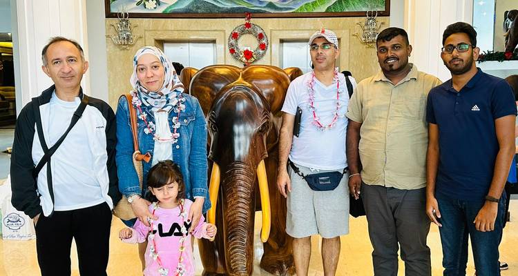 Groupe familial posant avec une statue d'éléphant décorative.