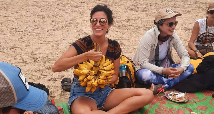 Des gens profitant d'un pique-nique avec des bananes sur une couverture.