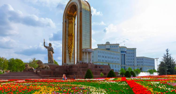 Denkmal mit einer Statue, umgeben von lebendigen Blumengärten.