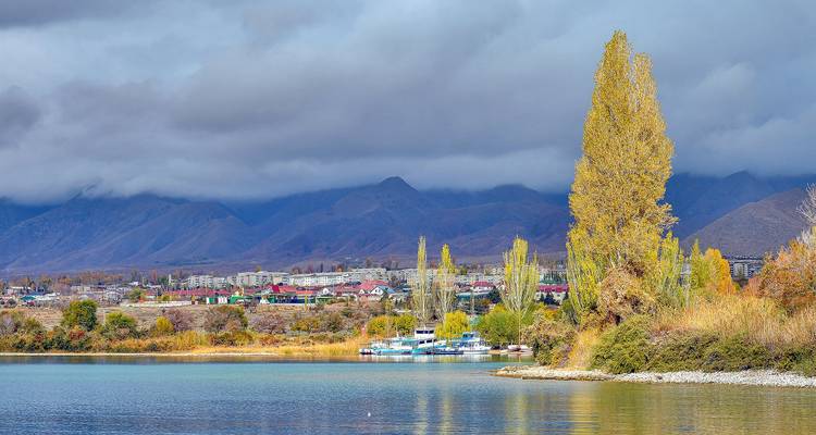 Malerischer See mit Bergen und bunten Bäumen.