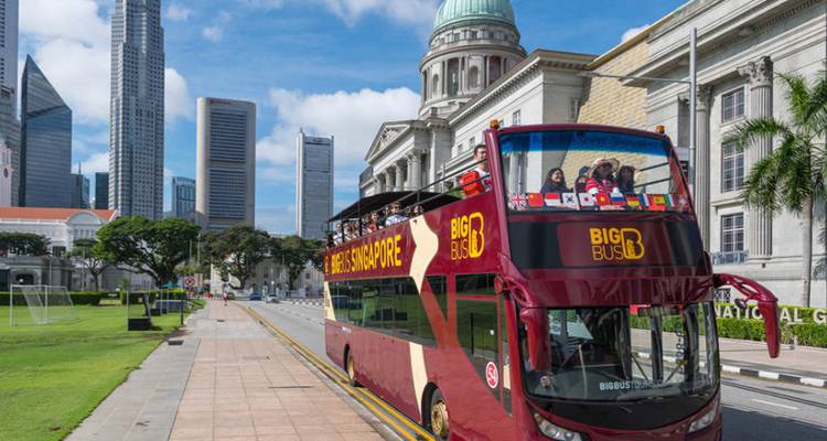 Autobús turístico con personas, y el horizonte de Singapur de fondo.