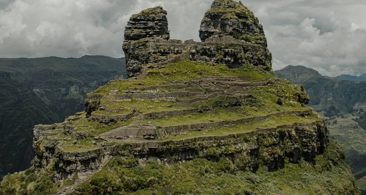 Formación montañosa escalonada con vegetación exuberante.