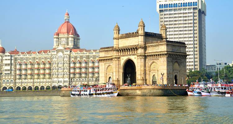 Puerta de la India con barcos y paisaje urbano de fondo.