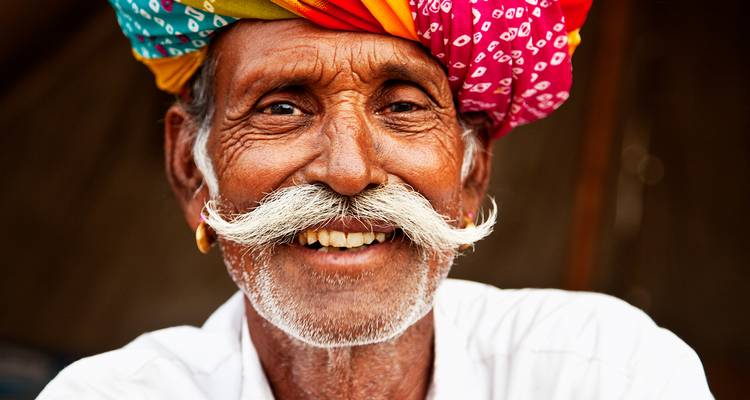 Hombre feliz en vestimenta étnica sonriendo.