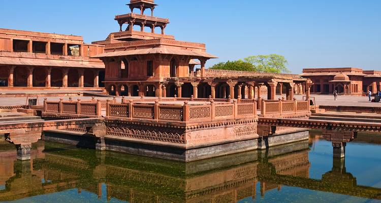 Sierlijke rode zandstenen paviljoen weerspiegeld in een vijver bij Fatehpur Sikri