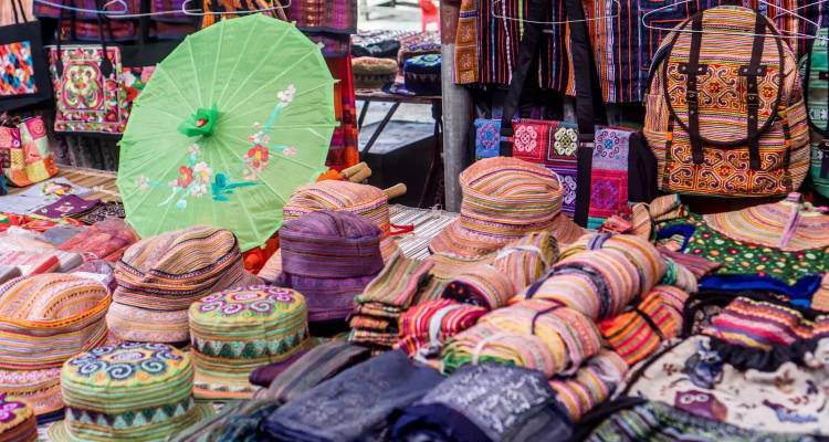 Sombreros tradicionales coloridos y artesanías en exhibición en un mercado.